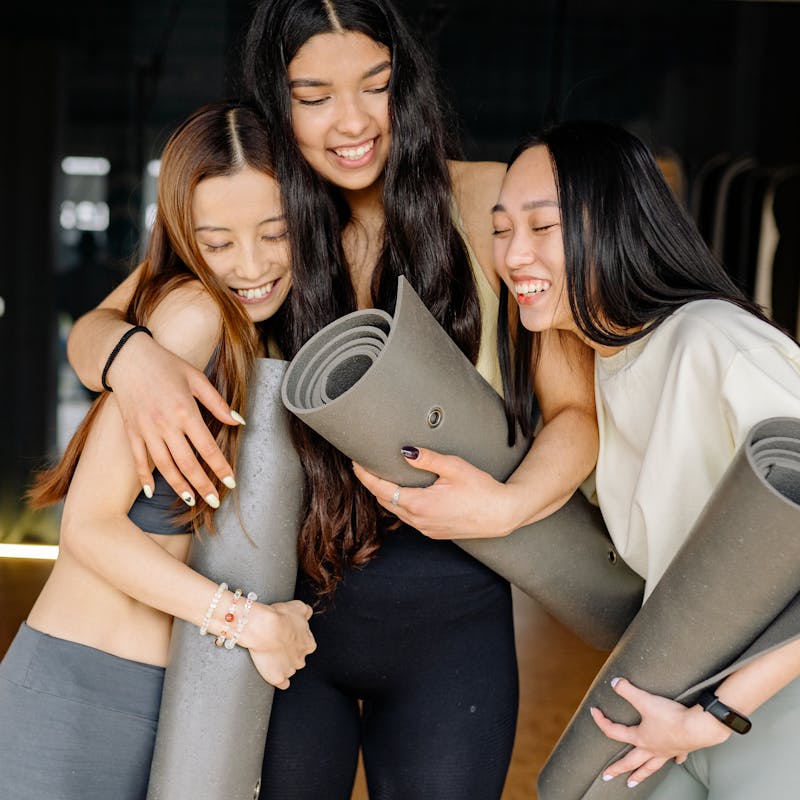  Smiling people engaging in various wellness activities, such as yoga, meditation, or a community gathering.